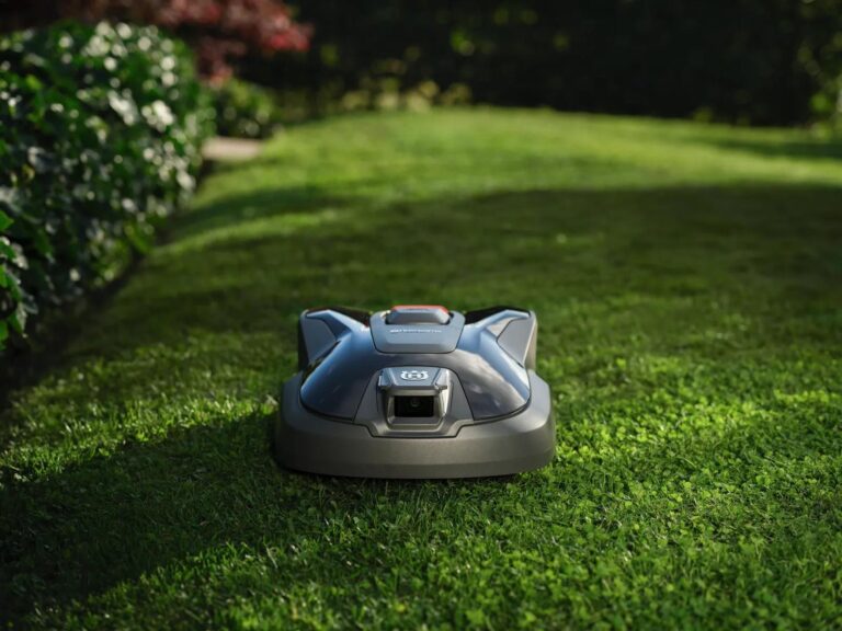 Moderne robotmaaier in actie op gazon - automatisch tuinonderhoud met draadloze technologie